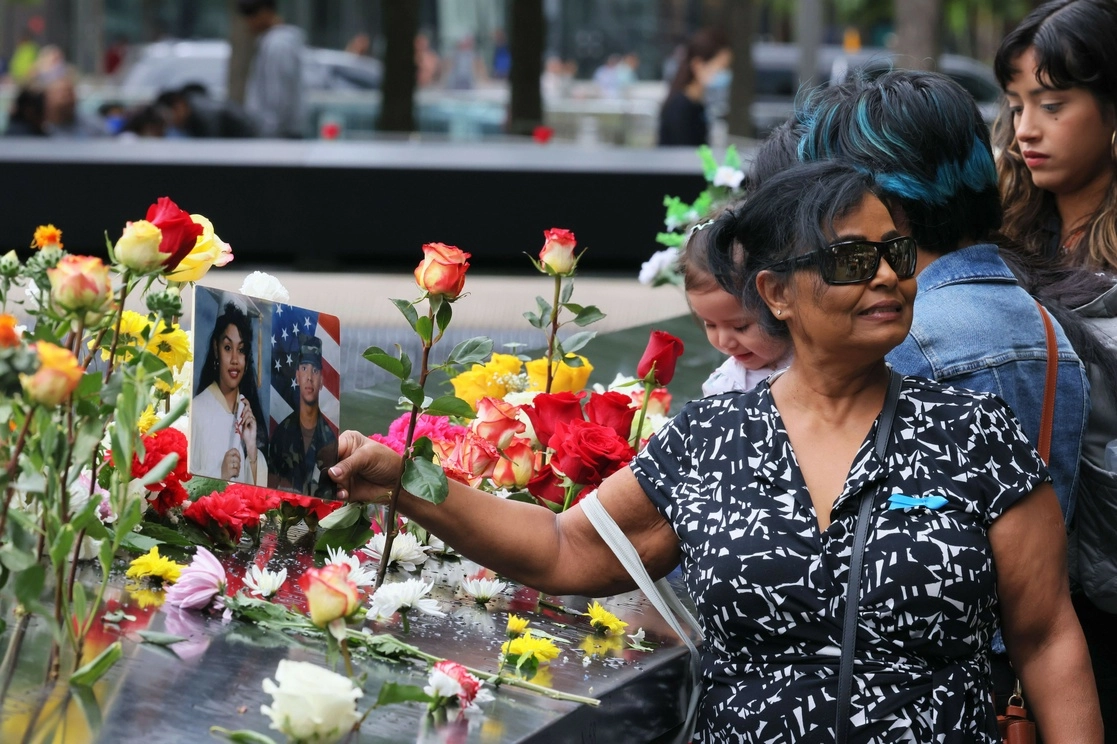 Familiares de víctimas de los atentados contra las torres del World Trade Center perpetrados por el grupo yihadista Al Qaeda el 11 de septiembre de 2001 llevaron flores y retratos al monumento construido en su memoria en Manhattan, Nueva York. Foto Afp 