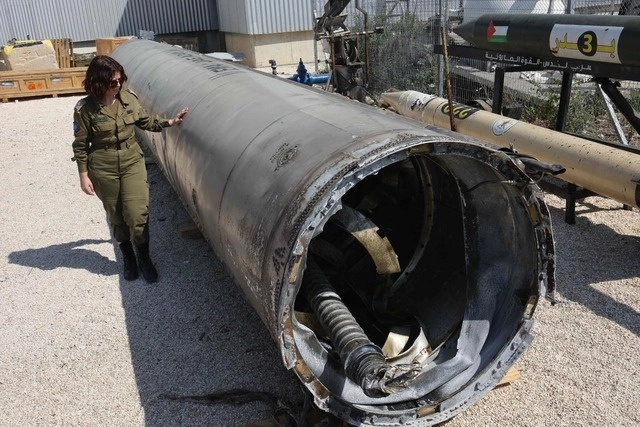 Un miembro del ejército israelí se encuentra junto a un misil balístico iraní que cayó en Israel el fin de semana. Foto Afp