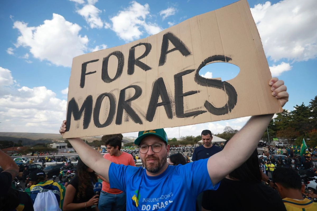 Un simpatizante Jair Bolsonaro sostiene un cartel en portugués que dice "Moraes, fuera", en referencia al juez de la Corte Suprema Alexandre de Moraes, encargado del juicio en contra del ex presidente brasileño, el 29 de julio de 2025. Foto 