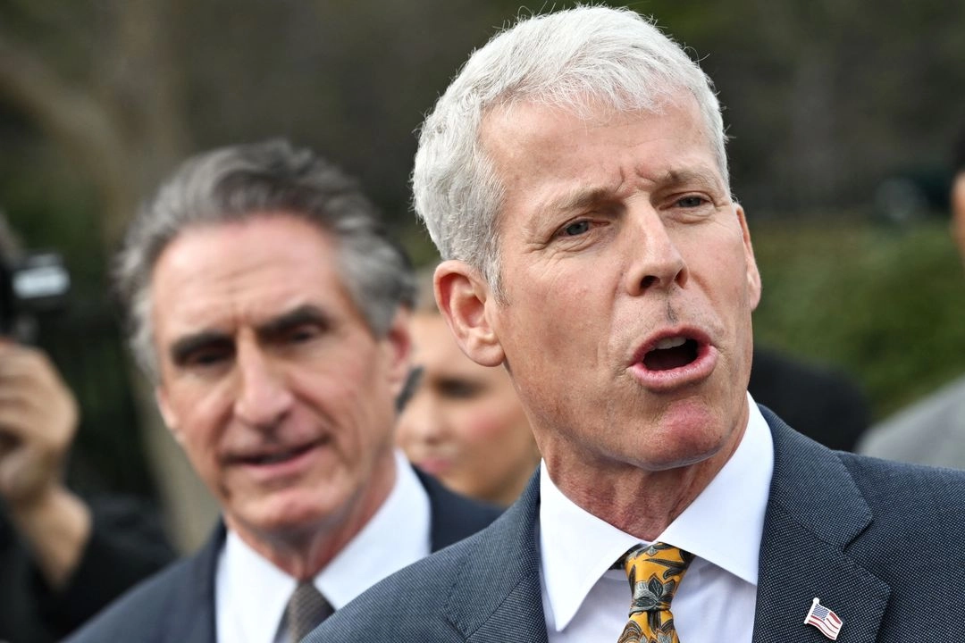 El secretario de Energía, Chris Wright, sostiene una copia de la "Evaluación energética, económica y ambiental de las exportaciones estadounidenses de GNL" mientras él y el secretario del Interior, Doug Burgum (izq.), hablan con la prensa frente al Ala Oeste de la Casa Blanca en Washington, D.C., el 19 de marzo de 2025. Foto 