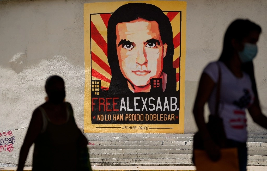 Viandantes pasan junto a un póster que pide la liberación de Alex Saab, en Caracas, Venezuela, el 9 de septiembre de 2023. Foto Ap 