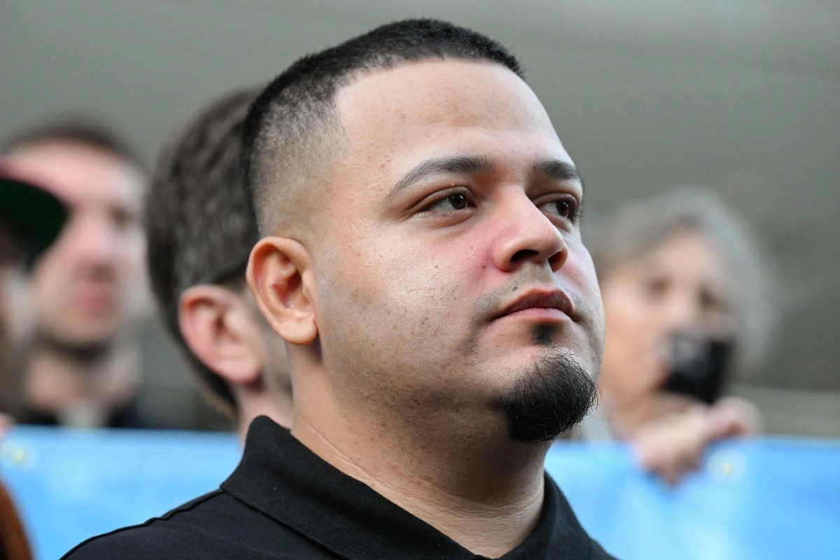 El migrante salvadoreño y residente estadounidense Kilmar Ábrego García observa a sus partidarios hablar con la prensa a su llegada a una oficina local del Servicio de Inmigración y Control de Aduanas (ICE) en Baltimore, Maryland, el 25 de agosto de 2025. Foto