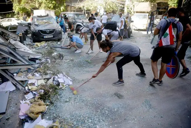 Activistas libaneses participan en una campaña para remover los escombros en Beirut, tras la explosión de ayer. Foto Afp
