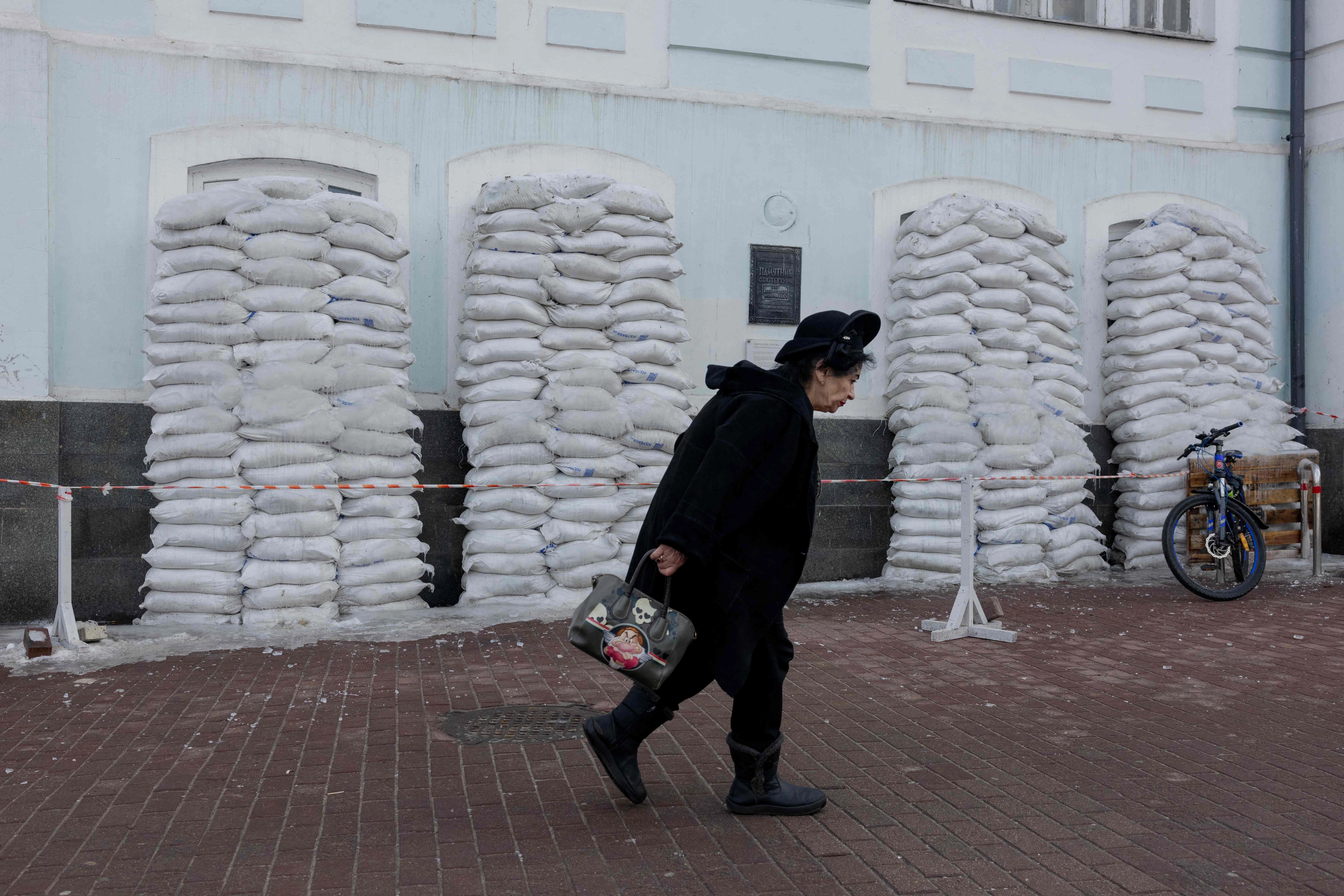Una mujer pasa junto a sacos de arena protectores en Kiev en medio de la invasión rusa a Ucrania. Foto