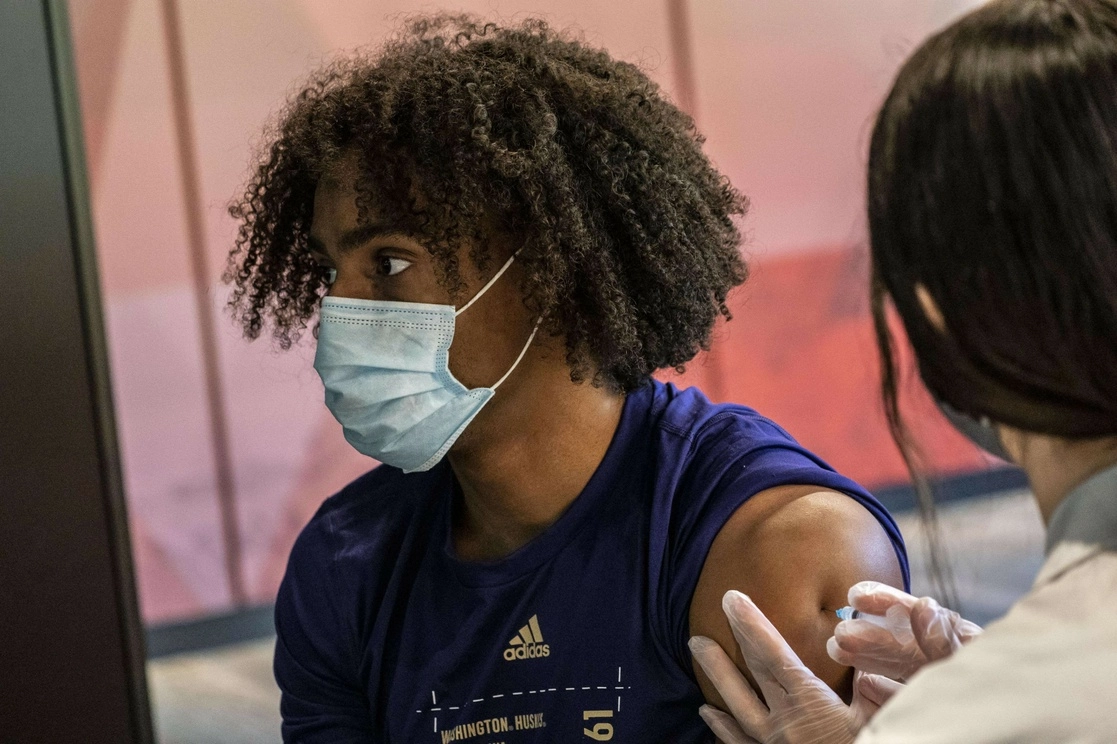 Joven vacunándose en Seattle. Foto Afp