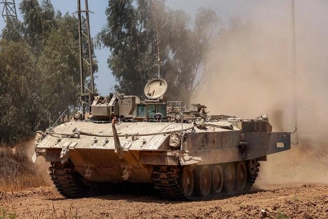 Un vehículo blindado de transporte de personal israelí avanza a lo largo de la valla en la frontera sur de Israel con la Franja de Gaza. Foto 