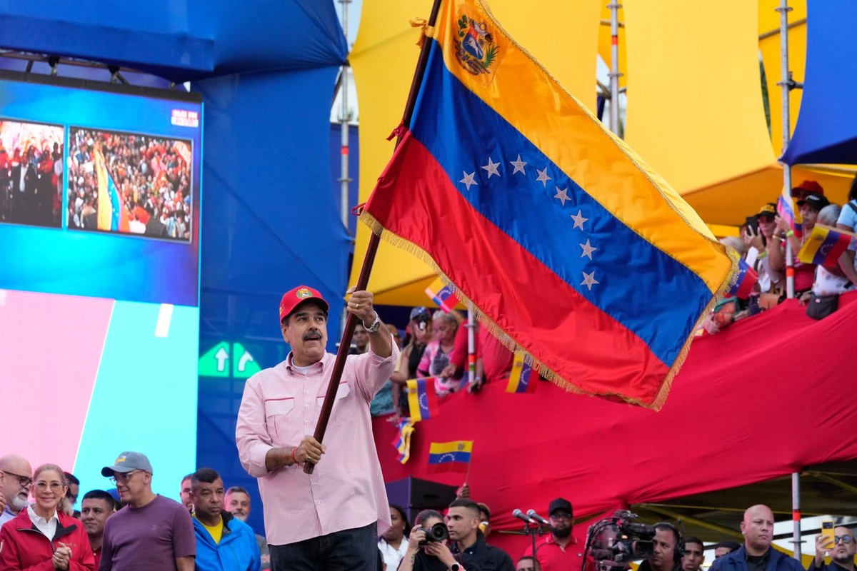 El presidente Nicolás Maduro ondea una bandera venezolana durante un evento de juramentación de los comités comunitarios organizados por el gobierno en el palacio presidencial en Caracas, Venezuela, el 1 de diciembre de 2025.