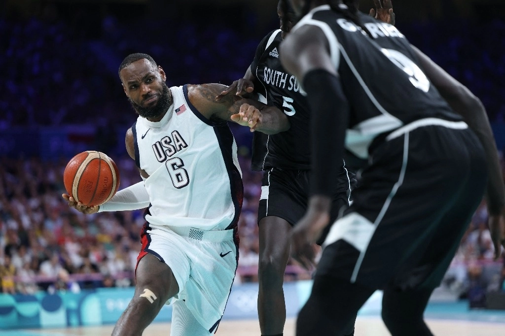  El número 06 de EE. UU., LeBron James, desafía al número 05 de Sudán del Sur, Nuni Omot, en el partido de baloncesto del grupo C de la ronda preliminar masculina entre EE. UU. y Sudán del Sur durante los Juegos Olímpicos de París 2024. Foto Afp