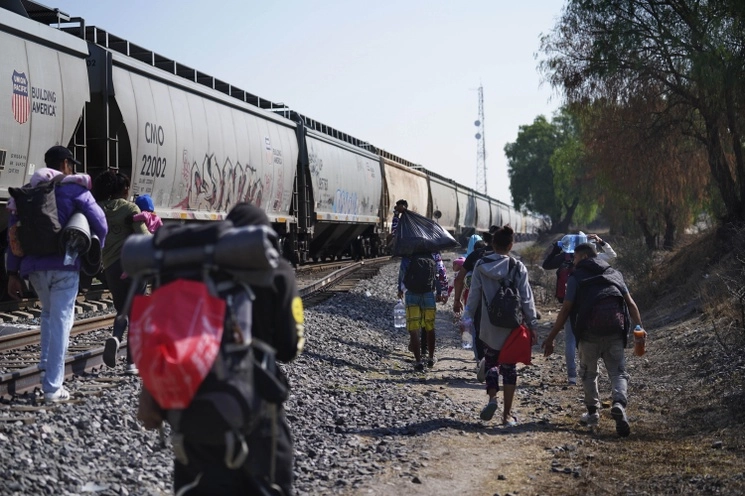 Migrantes intentan subir a un tren que pasa por Huehuetoca, Estado de México. Foto Ap