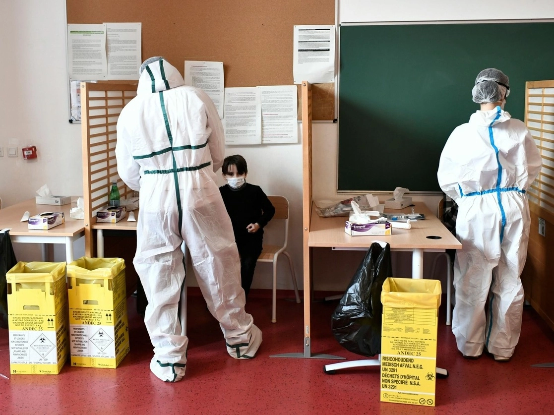 Trabajadores de la salud recolectan muestras de saliva de alumnos de una escuela en París, para analizarlas con pruebas de coronavirus, el 11 de febrero de 2021. Foto Afp 