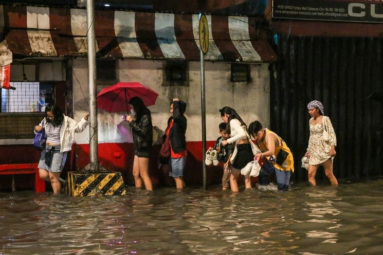 La gente camina por una calle inundada de Manila mientras la tormenta tropical Khanun intensifica la lluvia monzónica del suroeste, 29 de julio de 2023. Foto Afp
