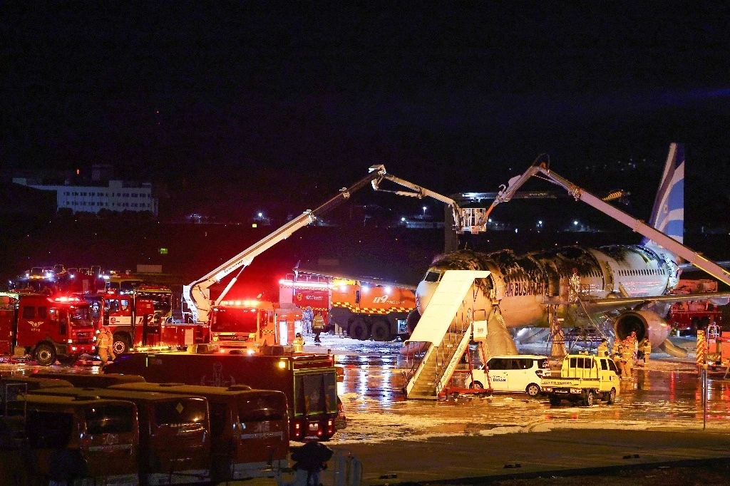 Bomberos después de que se produjera un incendio en un avión de pasajeros de Air Busan con destino a Hong Kong, en el Aeropuerto Internacional de Gimhae en Busan el 28 de enero de 2025. Foto Afp