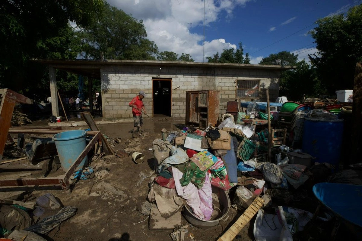 Pobladores del Aguacate, Veracruz laboran juntas para limpiar sus viviendas, la ayuda oficial aún no les llega pues el río tiró el puente de acceso a su comunidad. Foto