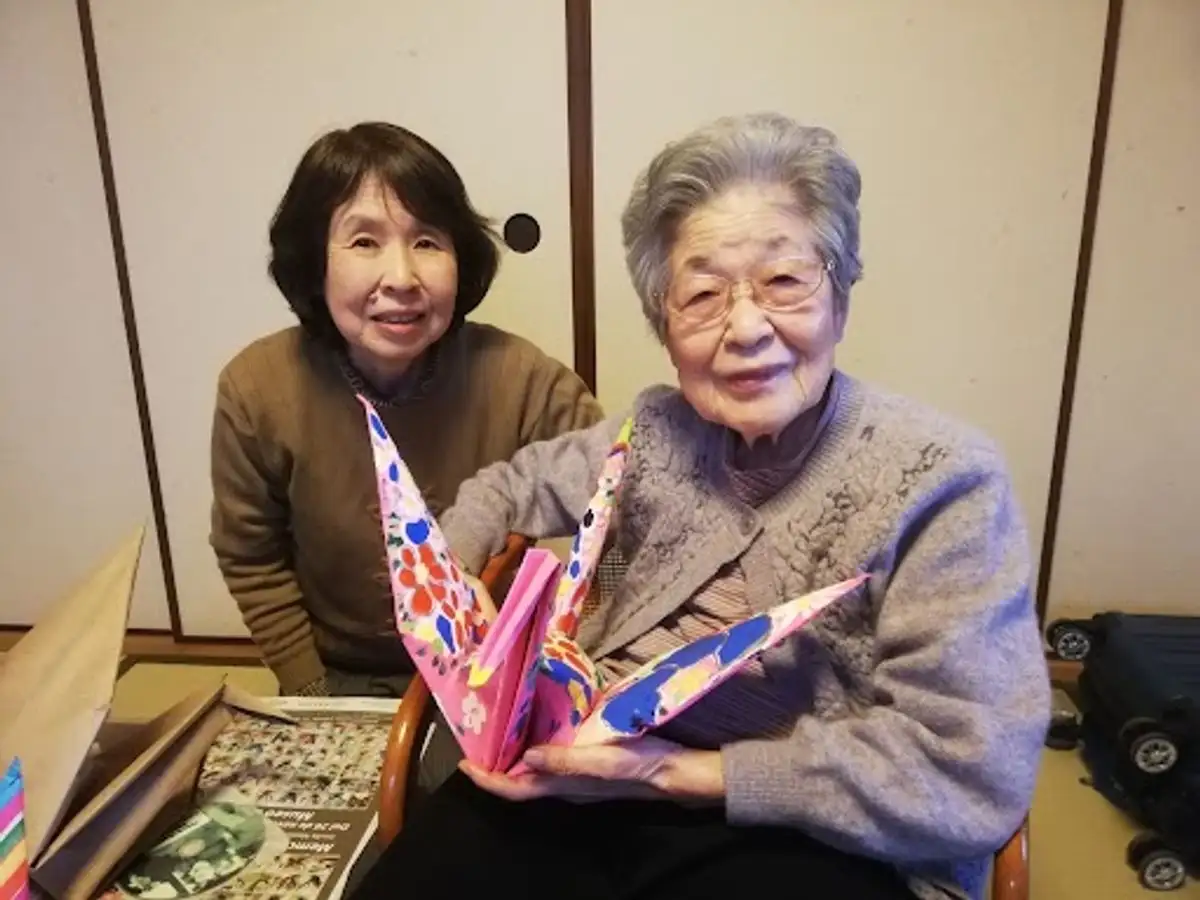 La sobreviviente Megumi Shinoda carga una grulla mexicana de la artista de origen japonés Mari Sano. 