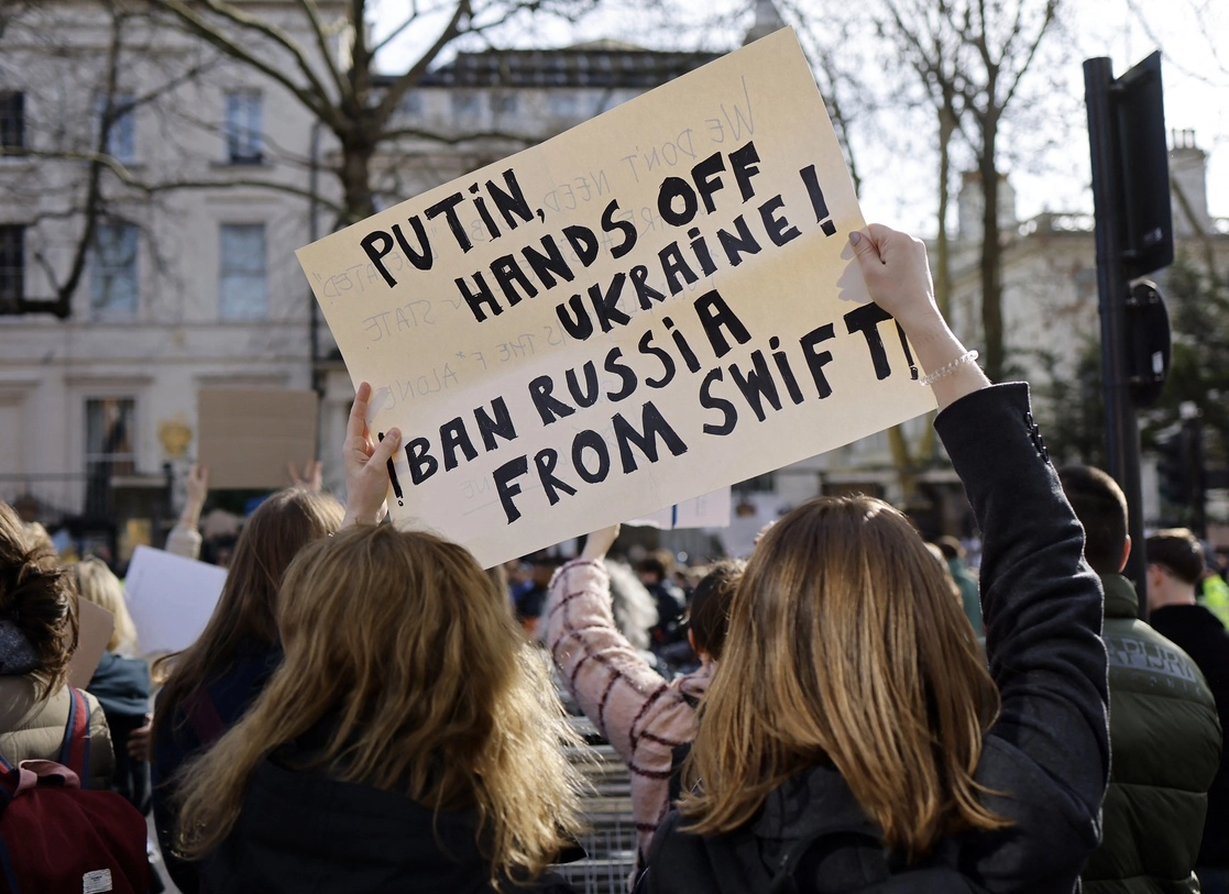 Manifestantes levantan una pancarta en la que piden excluir a Rusia del sistema bancario Swift, durante una protesta contra la invasión rusa a Ucrania en Londres, el 26 de febrero de 2022. Foto Afp 