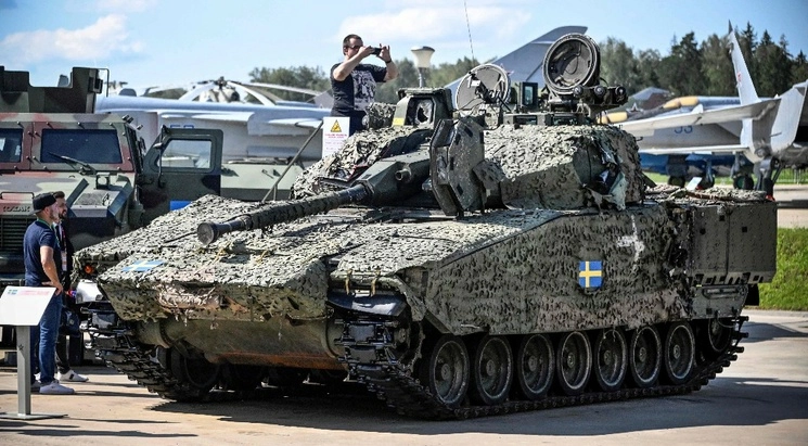 Personas se toman fotos con un vehículo de combate blindado CV9040 sueco capturado en el campo y  exhibido en Kubinka Patriot Park, ubicado a las afueras de Móscú, el 15 de agosto de 2023. Foto Afp 