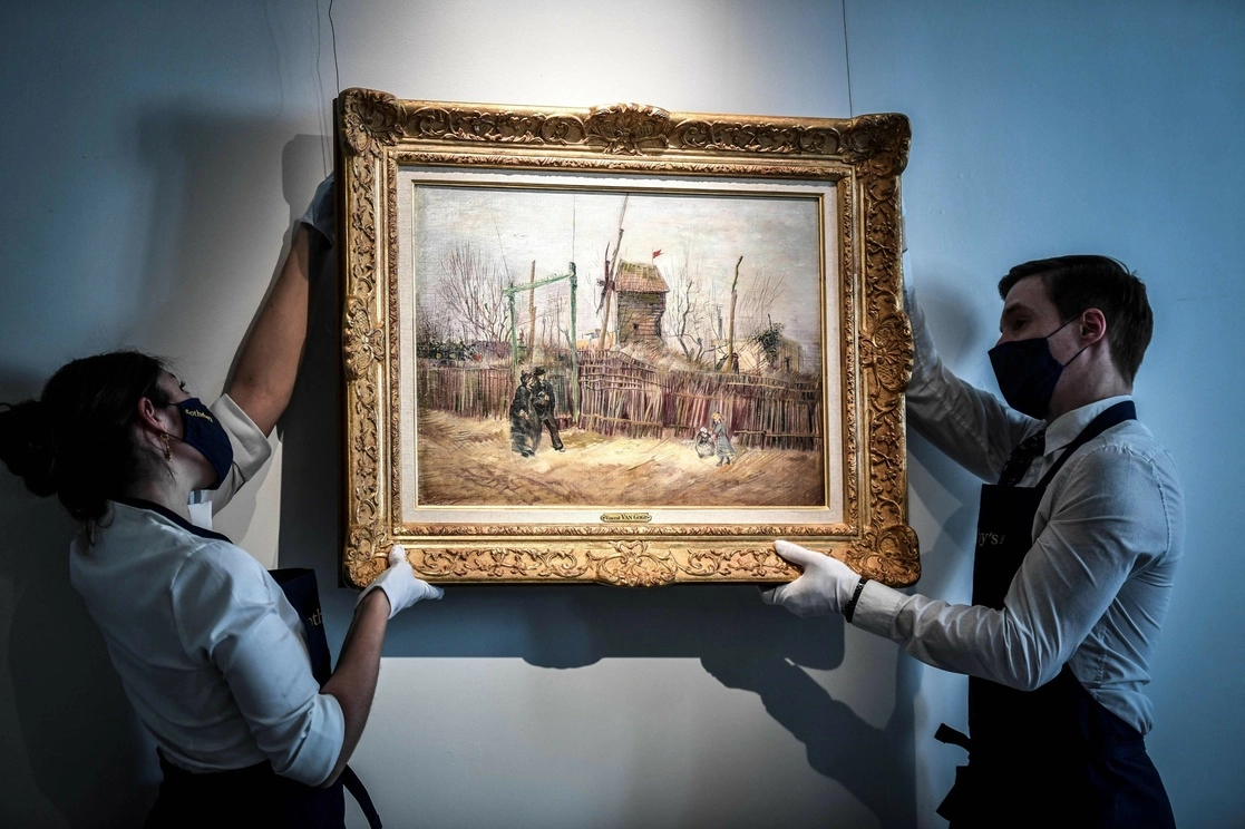 Dos empleados de la casa de subastas Sotheby's cuelgan la pieza para ser exhibida antes de que se venda, en París, Francia, el 24 de febrero de 2021. Foto Afp