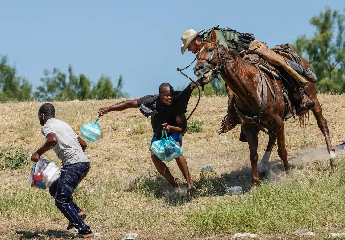 Un agente de la Patrulla Fronteriza de Estados Unidos trata de capturar a migrantes haitianos en Del Río, Texas, el 19 de septiembre de 2021. Foto Afp