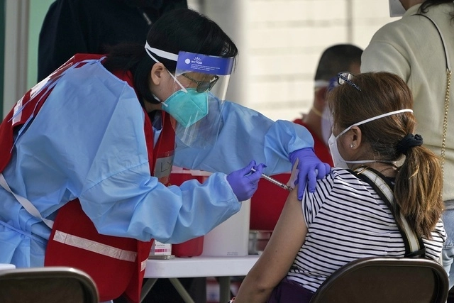 Personal de salud aplica la vacuna contra Covid-19 a una persona en la ciudad de Pacoima, California. Foto Ap / Archivo