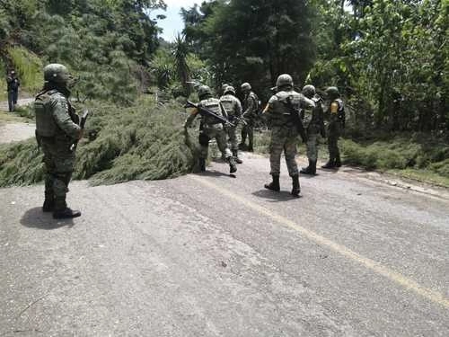 Elementos del Ejército retiran de la carretera Pantelhó-San Cristóbal, Chiapas, un árbol derribado por integrantes de un grupo armado. En ese punto, situado a cuatro kilómetros de la cabecera de Pantelhó, el 8 de julio fueron emboscados militares y policías, con saldo de nueve uniformados heridos de bala. Foto Elio Henríquez