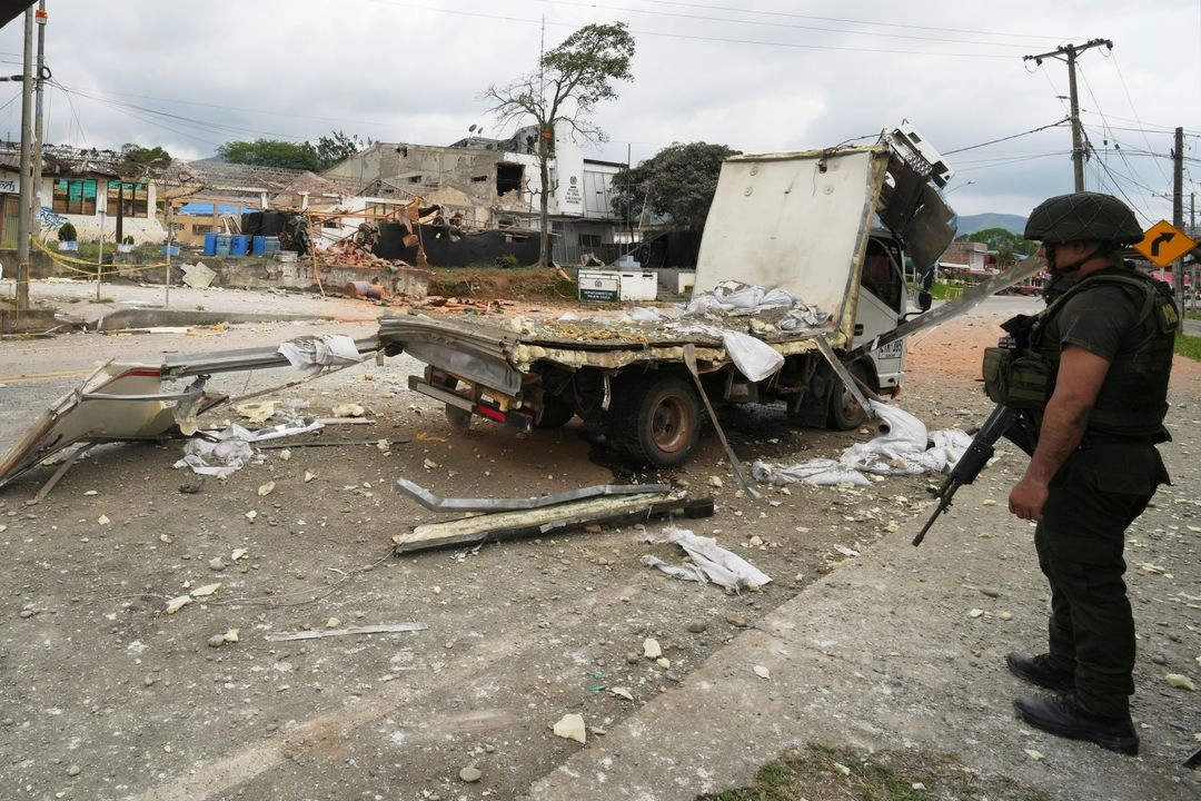 Un policía monta guardia cerca de un camión que se utilizó para atacar una estación de policía con explosivos en Mondomo, Colombia, el jueves 17 de abril de 2025. Foto