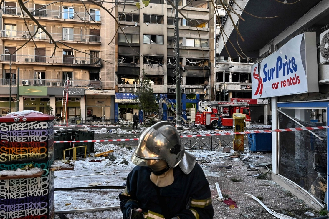 Un bombero revisa los daños tras la explosión e incendio que destruyó partes de edificios en el centro de Atenas, el 26 de enero de 2022. Foto Afp 