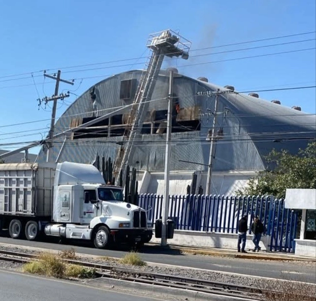 Desde la calle se puede observar fuego y humo que sale de una de las ranuras cuadrangulares de la parte superior de la nave industrial donde se produjo la detonación. Foto La Jornada 