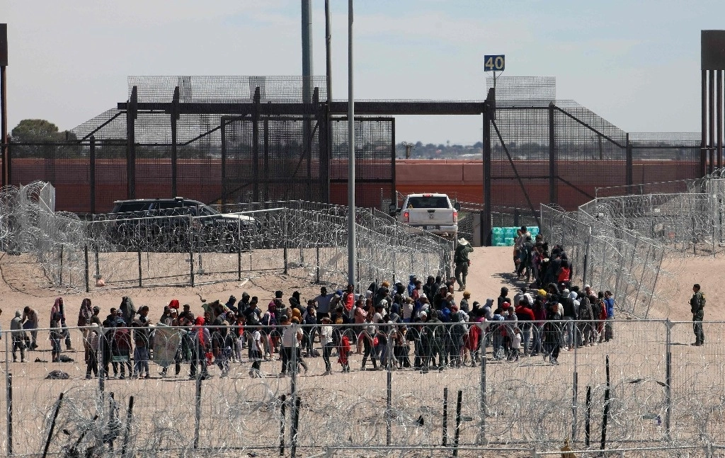Migrantes hacen fila para ser deportados por la Patrulla Fronteriza de EU tras haber cruzado el río Bravo por El Paso, Texas, el 18 de abril de 2024. Foto Afp