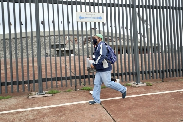 Un joven corre hacia la entrada del estadio olímpico en CU para realizar su examen de admisión a la licenciatura a la UNAM, el pasado agosto de 2020. Foto Luis Castillo / Archivo