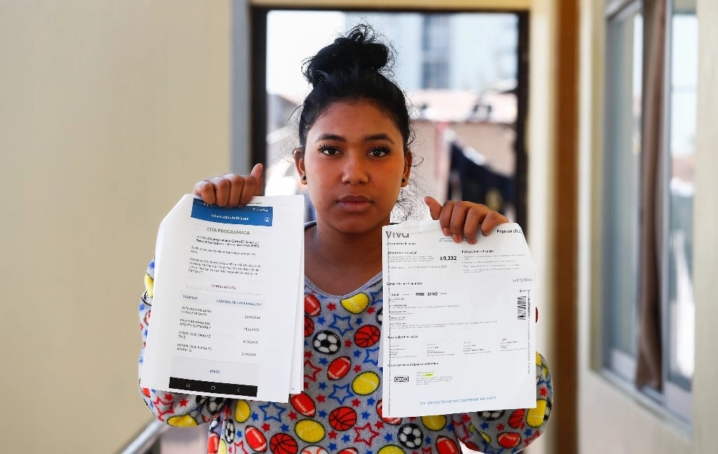 En el albergue Arcángel Rafael, ubicado en Iztapalapa, Amanda Aponte muestra la cancelación de la cita programada para que ella y su familia solicitaran asilo a Estados Unidos. Foto Víctor Camacho 