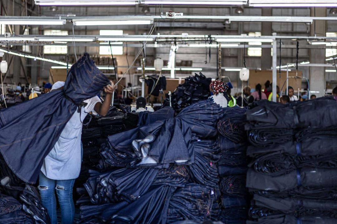 Un trabajador lleva unos jeans terminados en una fábrica textil en imagen de archivo. Foto