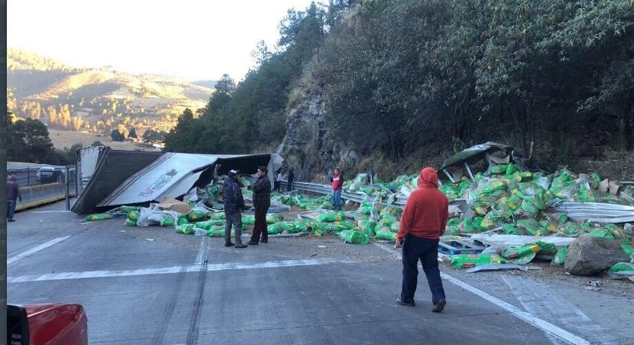 La unidad, que transportaba alimento para mascotas, dejó el producto regado sobre la carpeta asfáltica, por lo que fue necesario cerrar la vía de cuota con dirección a Puebla. Foto ‘La Jornada’