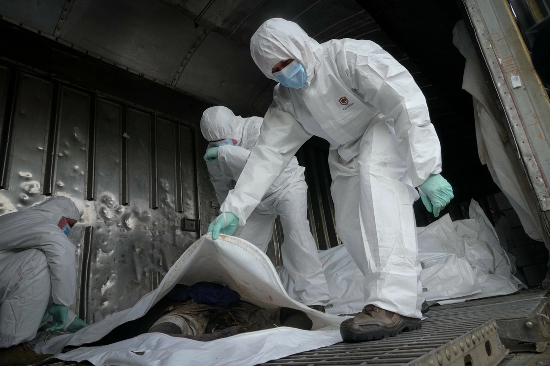 Militares ucranios identifican cuerpos de soldados rusos en un vagón frigorífico en Kiev, Ucrania. Foto Ap