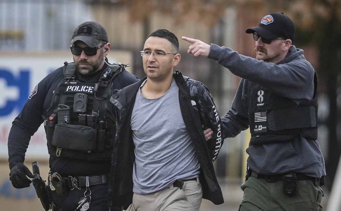 Solomon Peña (centro), seguidor del ex presidente Donald Trump, es trasladado a las instalaciones de la policía de Albuquerque después de su arresto por organizar ataques armados contra legisladores demócratas. Foto Ap.