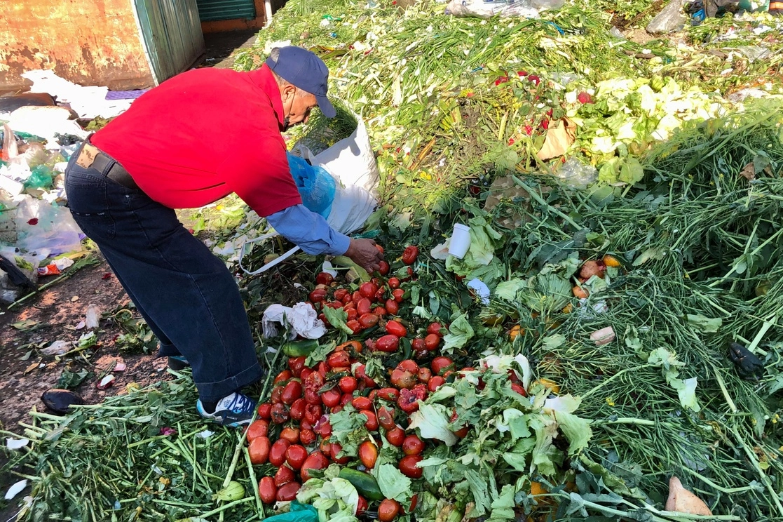 Un hombre busca verduras en buen estado en un área de desperdicios en la Central de Abasto de la Ciudad de México. Foto Luis Castillo