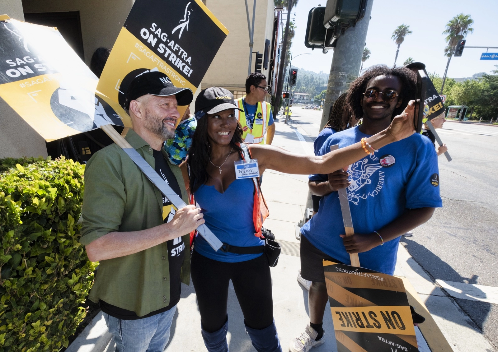 La actriz y productora Tanjareen Thomas, en el centro, se toma una selfie con el actor Jon Cryer, a la izquierda, y Soloman Ghirmai, partidario de la WGA, a la derecha. Foto Ap