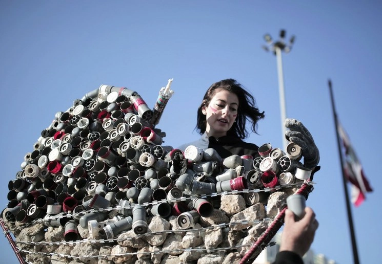 Hayat Nazer, artista libanesa, hace un performance con restos de bombas en Beirut. Foto Afp