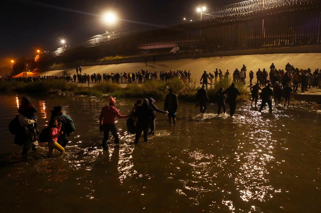 Unos mil 200 extranjeros cruzaron masivamente el río Bravo y formaron una gran hilera frente al muro fronterizo estadunidense, entre la noche del domingo y el lunes, después de llegar en caravana a Ciudad Juárez, Chihuahua. Foto Afp