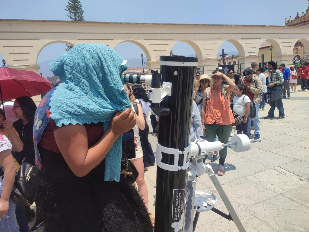 Originaria de Chamula, la mujer rechazó también que se le tomaran fotografías mostrando su cara, por lo que a la hora que se colocó frente el telescopio cubrió toda su cabeza con un chal celeste. Foto Elio Henríquez
