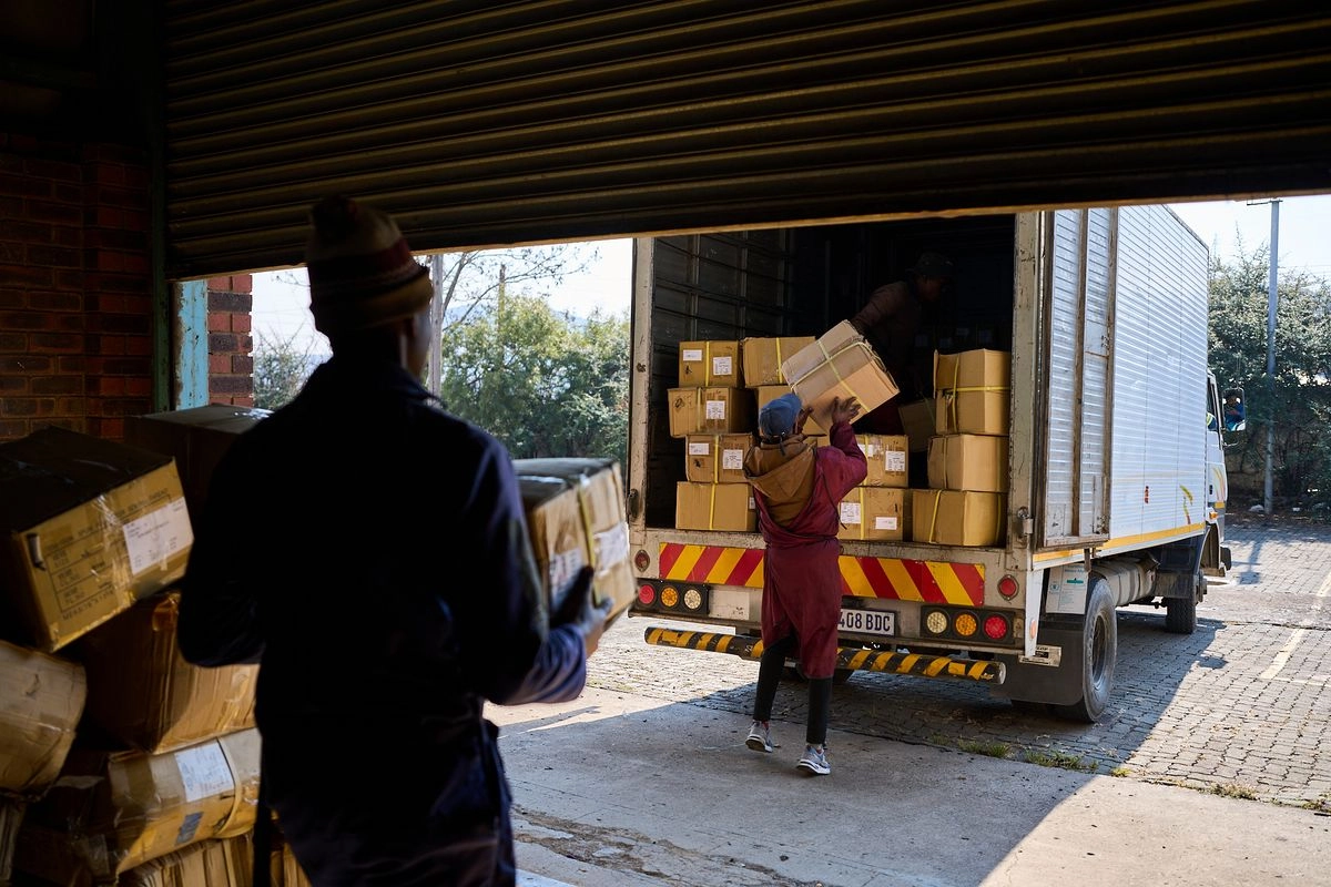 rabajadores cargan un camión con las últimas cajas de ropa de la fábrica de ropa Tzicc, vacía tras la amenaza de aranceles impuesta por Estados Unidos en Maseru, Lesoto, el martes 22 de julio de 2025. Foto