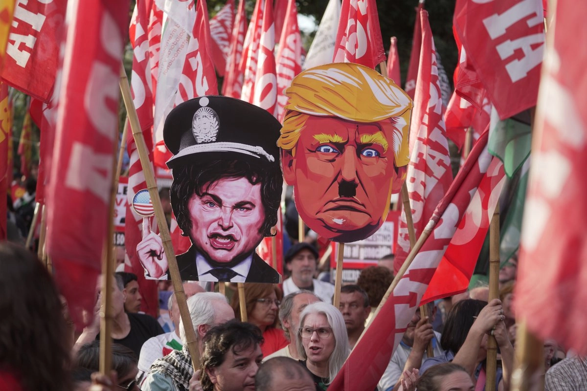 Manifestantes antigubernamentales sostienen carteles satirizando al presidente estadunidense Donald Trump y al presidente argentino Javier Milei durante una manifestación frente a la embajada de Estados Unidos en Buenos Aires. Foto