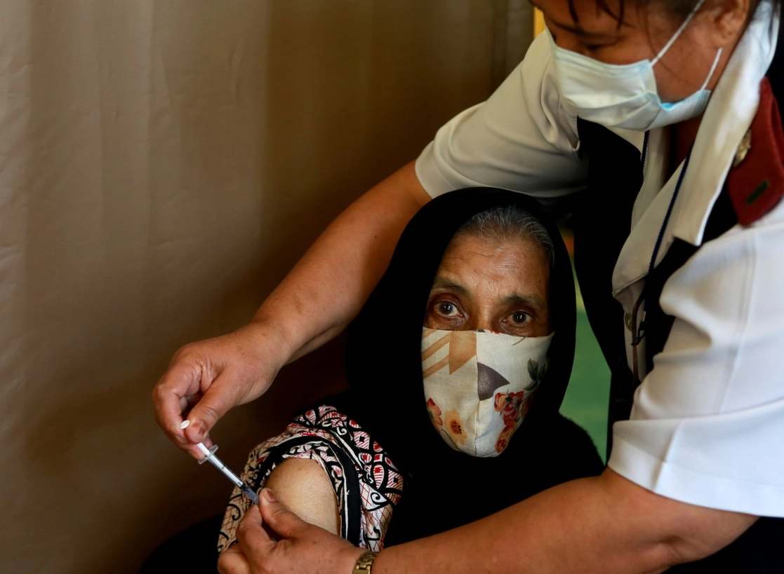 Kaironesa Sheik Suleman Allie, de 66 años, recibe una primera dosis de la vacuna Pfizer Covid-19 de un miembro del personal de salud en un centro de vacunación en el Hospital Karl Bremer, en Ciudad del Cabo, Sudáfrica, el 26 de mayo de 2021. Foto Ap