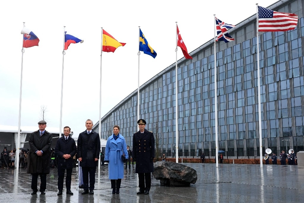 El primer ministro sueco, Ulf Kristersson, el secretario general de la OTAN, Jens Stoltenberg, y la princesa heredera Victoria de Suecia, posan frente a la bandera de Suecia después de una ceremonia para conmemorar la adhesión de Suecia a la OTAN en la sede de la OTAN en Bruselas, el 11 de marzo de 2024. Foto Ap
