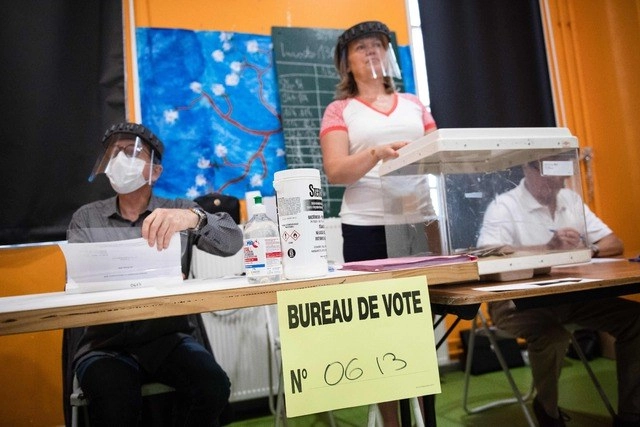 Funcionarios de casilla usan mascarilla y cubrebocas en la segunda vuelta de las elecciones municipales en Francia. Foto Afp