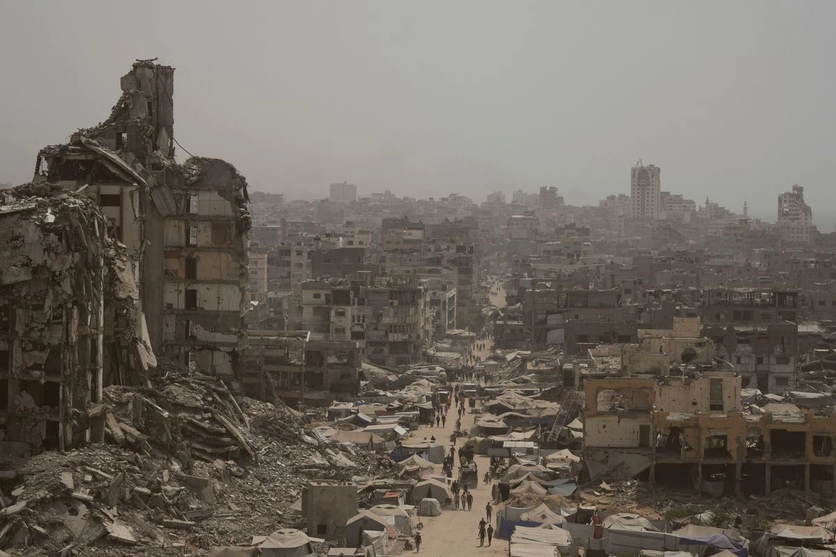 Palestinos caminan por una calle rodeada de edificios destruidos por los bombardeos israelíes en la Franja de Gaza, el 29 de julio de 2025.