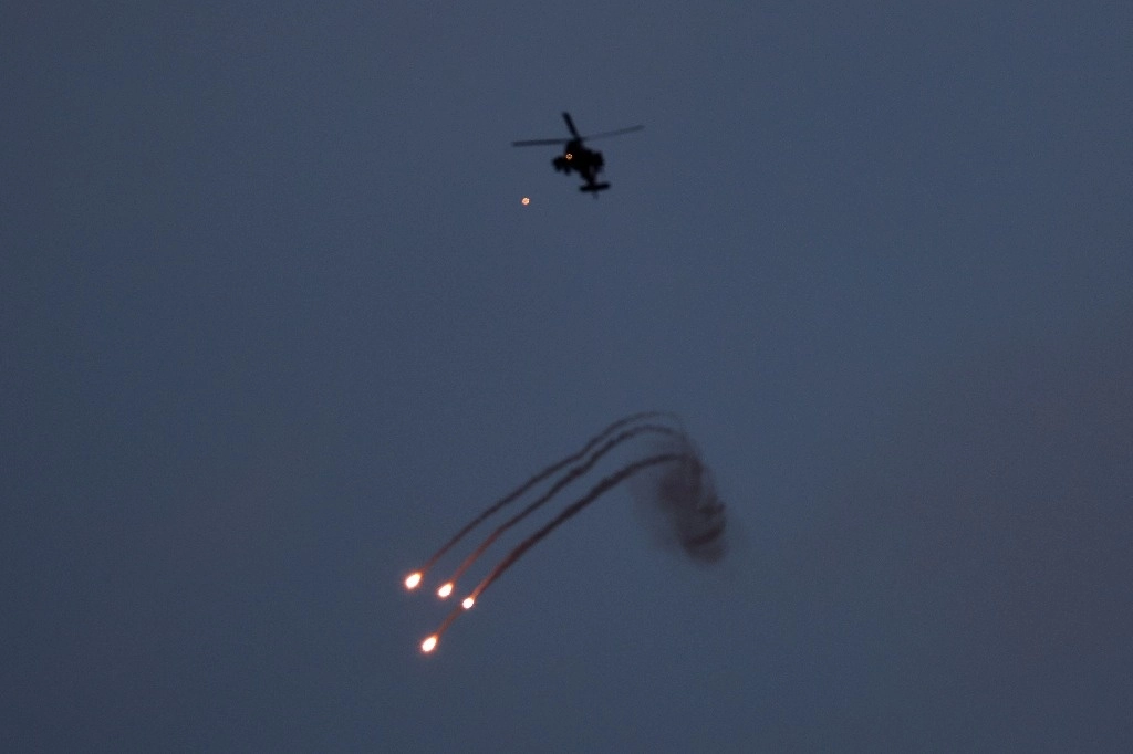 Helicóptero israelí arroja bengalas al norte de la Franja de Gaza. Foto Afp