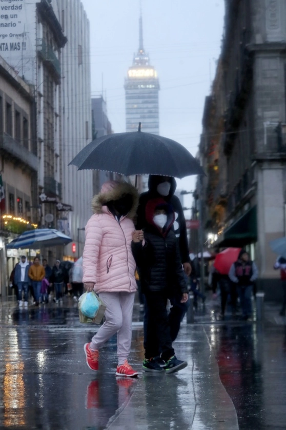 Jóvenes se protegen de la lluvia en imagen de archivo. Foto Roberto García Ortiz