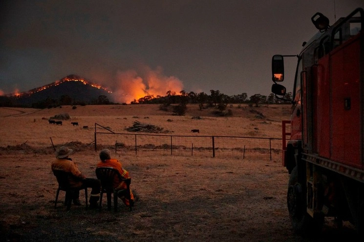 Bomberos voluntarios observan cómo el "mega incendio" de Nueva Gales del Sur se acerca a las afueras de la ciudad de Tumbarumba en Nueva Gales del Sur, en días pasados. Foto Greenpeace a través de AFP 