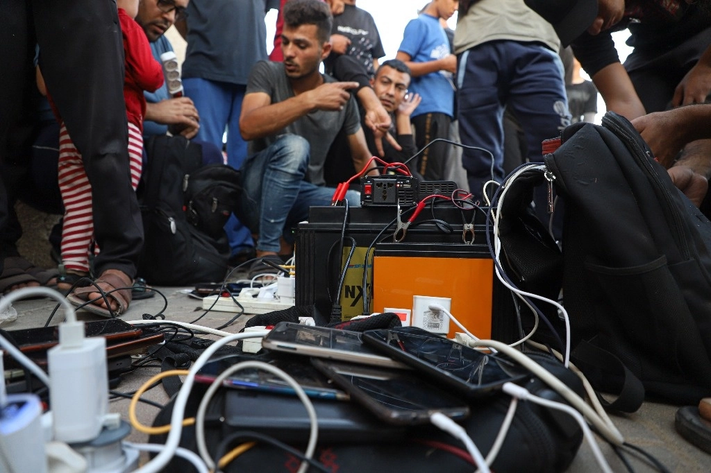 Gaza padece el corte total de electricidad y servicios de telefonía e Internet, lo que obliga a las personas a, por ejemplo, cargar celulares con baterías portátiles. La imagen, en la ciudad de Jan Yunis. Foto Xinhua