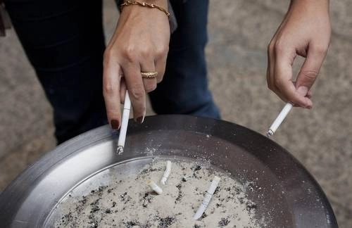 Personas fumando un cigarrillo en imagen de archivo. Foto Ap
